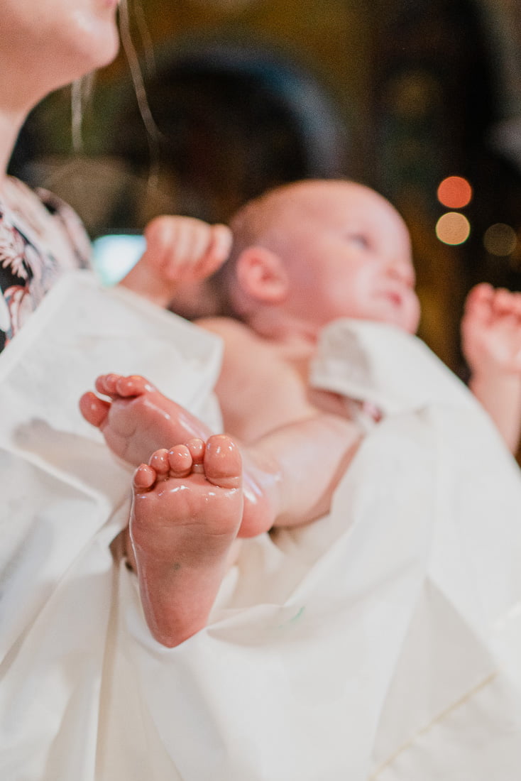 Οι πατουσίτσες από ένα μωράκι κατά τη διάρκεια μιας βάπτισης
